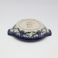 Round baking dish with handles made of Boleslawiec pottery.