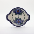 Round baking dish with handles made of Boleslawiec pottery.