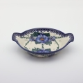 Round baking dish with handles made of Boleslawiec pottery.