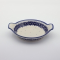 Round baking dish with handles made of Boleslawiec pottery.