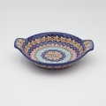 Round baking dish with handles made of Boleslawiec pottery.