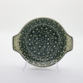 Round baking dish with handles made of Boleslawiec pottery.