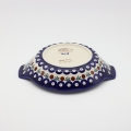 Round baking dish with handles made of Boleslawiec pottery.
