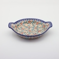 Round baking dish with handles made of Boleslawiec pottery.