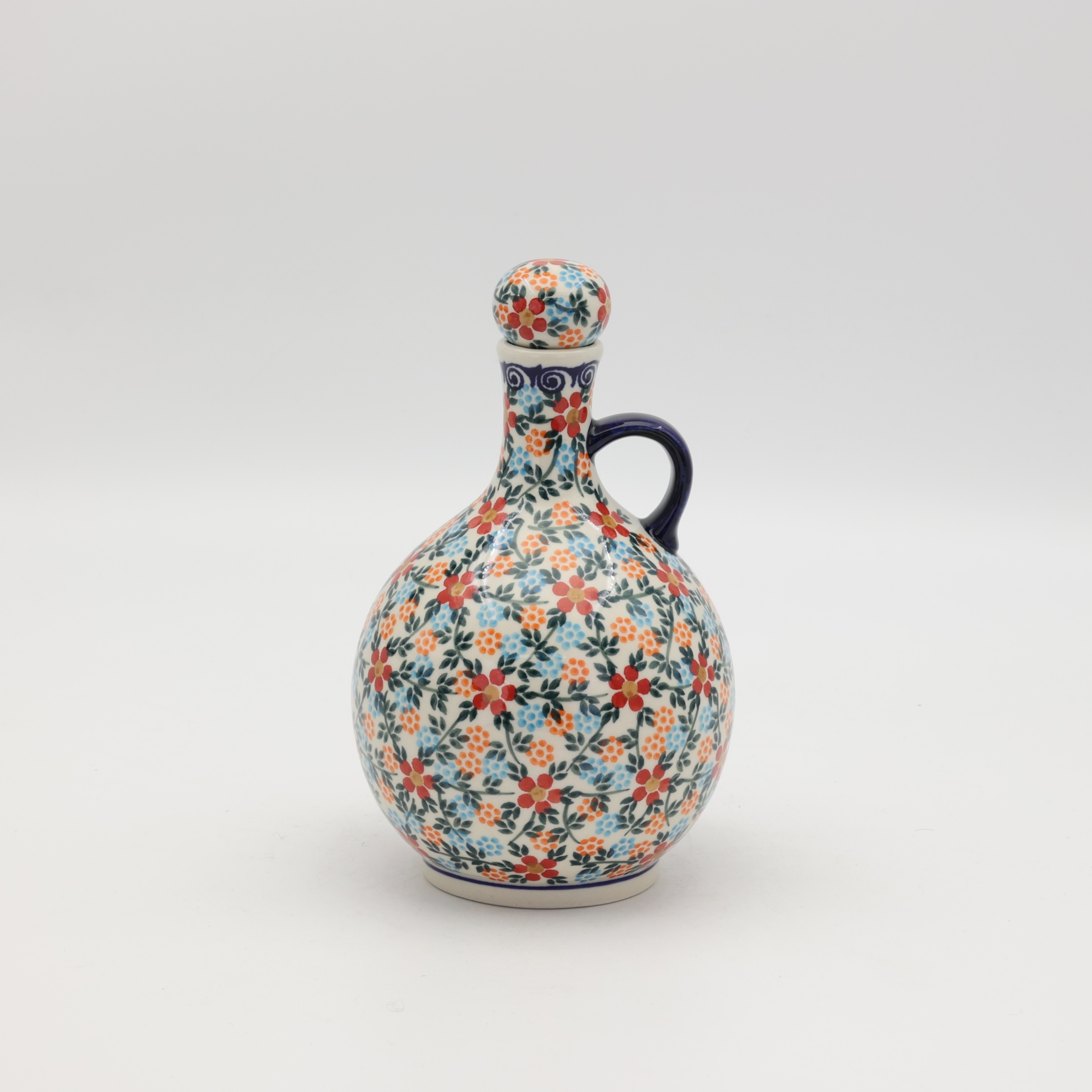Hand-painted round decanter made from traditional Bolesławiec pottery. Unique ceramic bottle perfect for serving liqueurs, water, or as a table decoration.